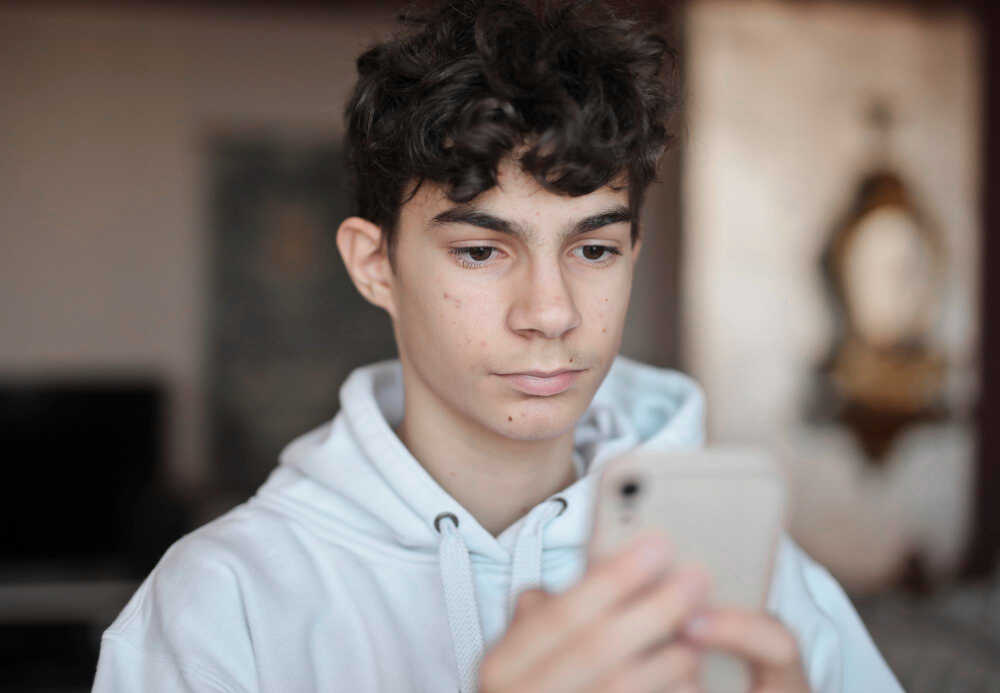 portret młodego chłopaka z iPhone w ręku