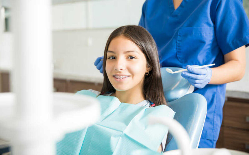 nastolatka na fotelu ortodontycznym podczas wizyty kontrolnej