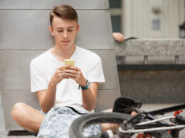 Młody chłopak przegląda aplikacje w telefonie