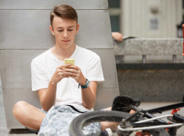 Młody chłopak przegląda aplikacje w telefonie